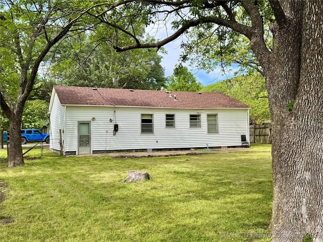 back of house featuring roof with shingles