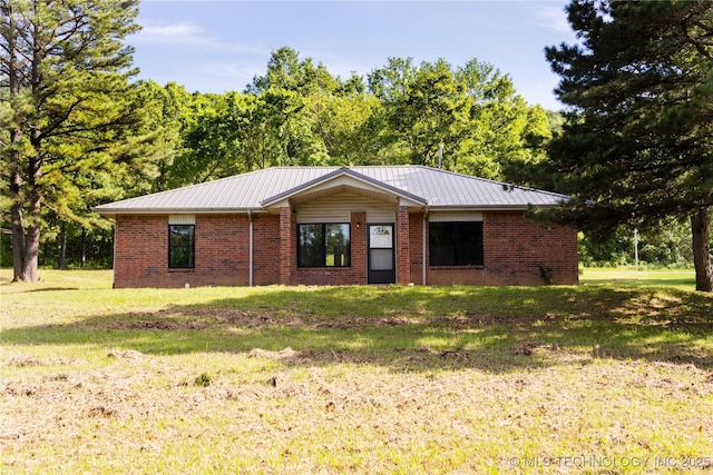 single story home featuring brick siding, metal roof, and a front lawn