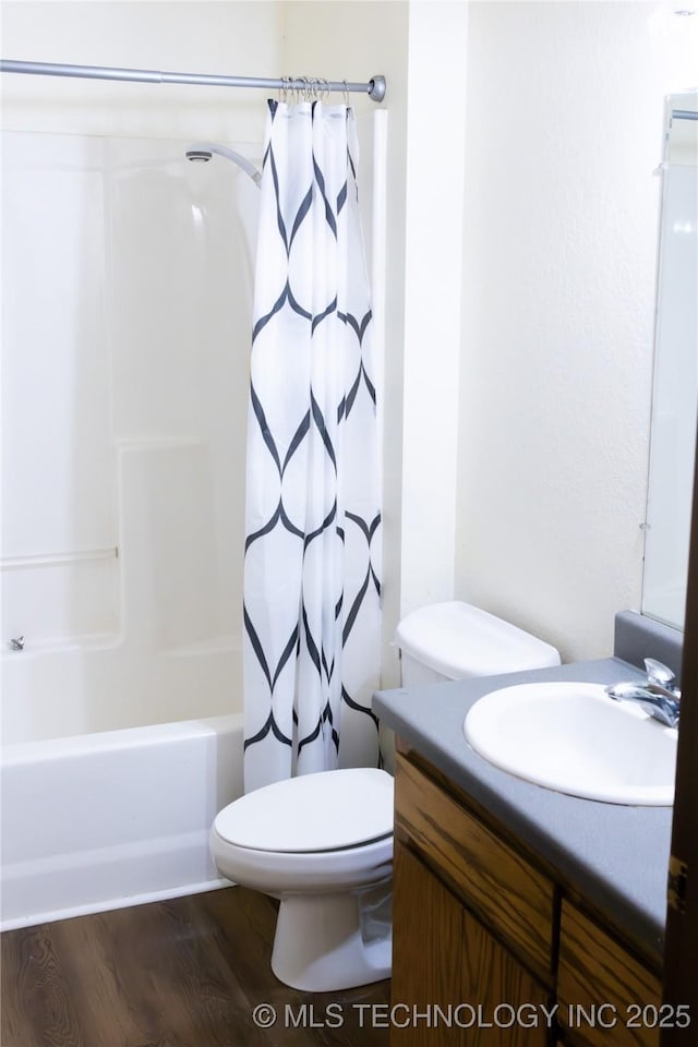 bathroom with vanity, wood finished floors, shower / bath combo, and toilet
