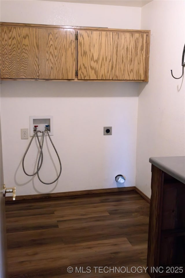 clothes washing area with baseboards, hookup for a washing machine, cabinet space, and wood finished floors