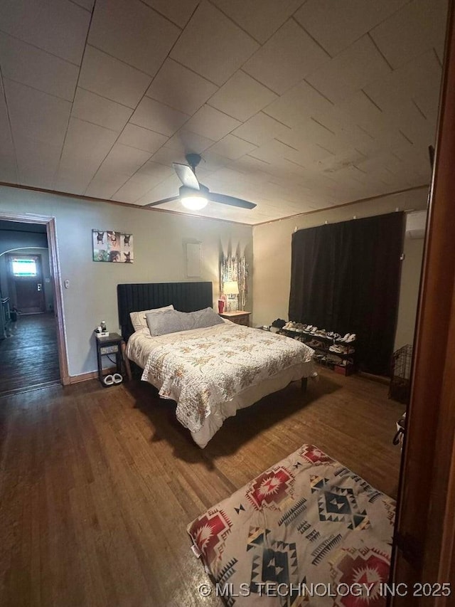 bedroom featuring baseboards, a ceiling fan, and wood finished floors