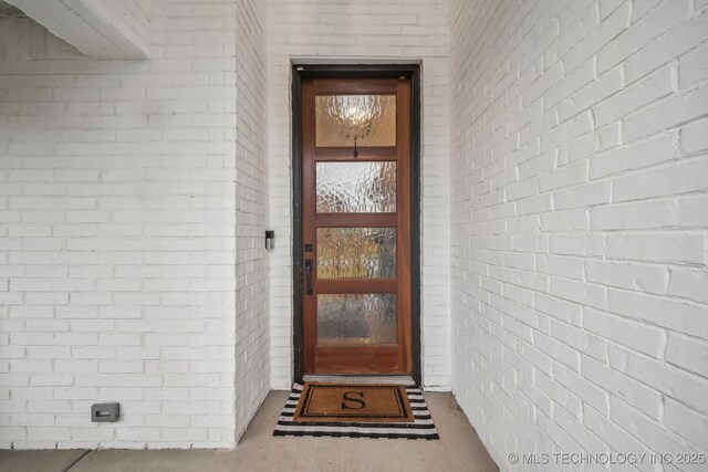 view of exterior entry featuring brick siding