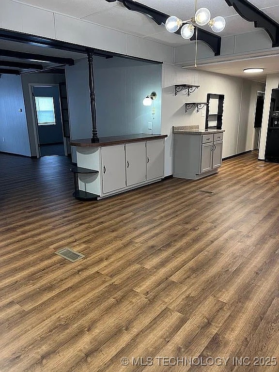 interior space with dark wood-style flooring, dark countertops, open shelves, and visible vents