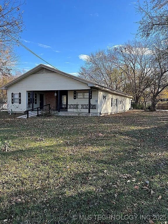 rear view of property with a lawn and a porch