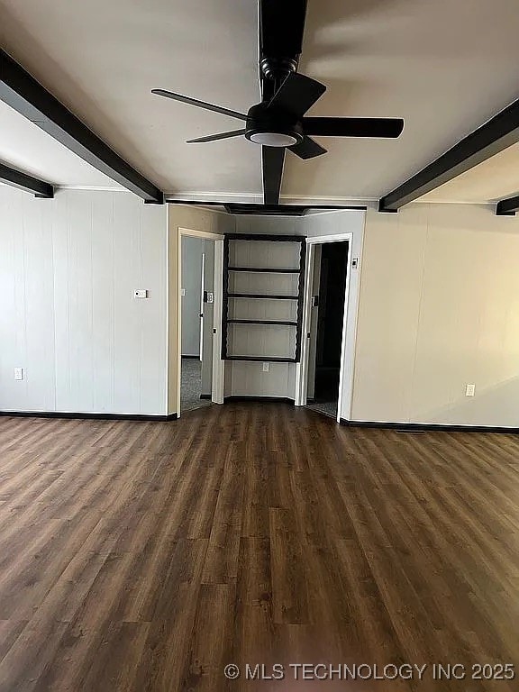 unfurnished living room with dark wood-style flooring, beam ceiling, and ceiling fan