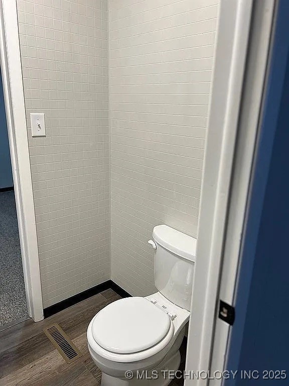 bathroom featuring toilet and wood finished floors