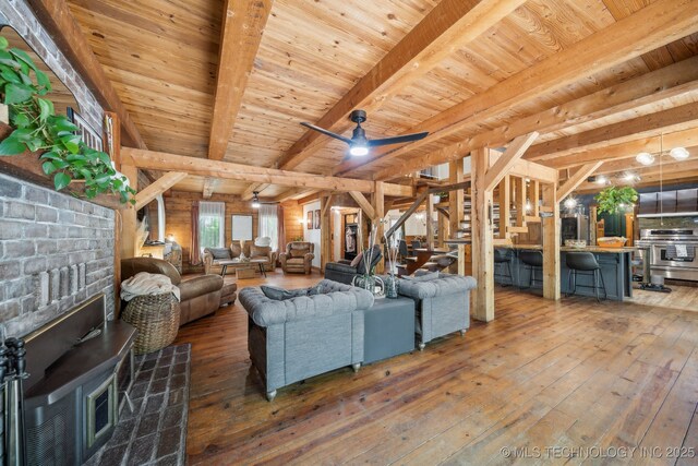 living room with wooden ceiling, hardwood / wood-style flooring, stairs, and beamed ceiling