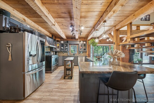 kitchen with appliances with stainless steel finishes, wooden ceiling, ventilation hood, decorative backsplash, and beam ceiling