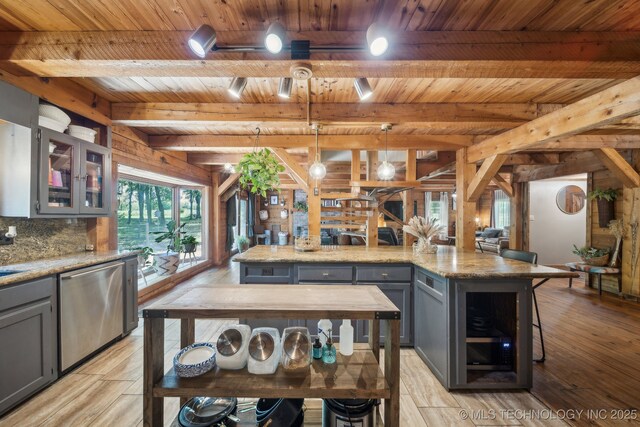 kitchen with light wood-type flooring, stainless steel dishwasher, gray cabinets, beamed ceiling, and wooden ceiling