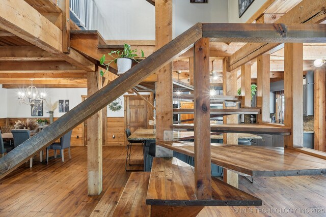 staircase featuring hardwood / wood-style floors and a chandelier