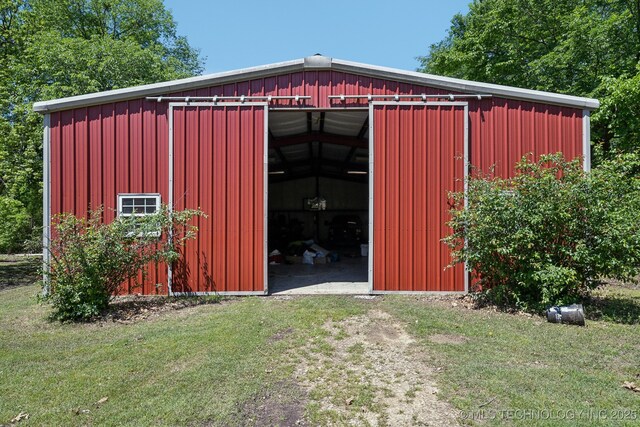 view of pole building with a lawn and dirt driveway