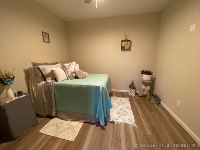 bedroom featuring wood finished floors, baseboards, and ceiling fan
