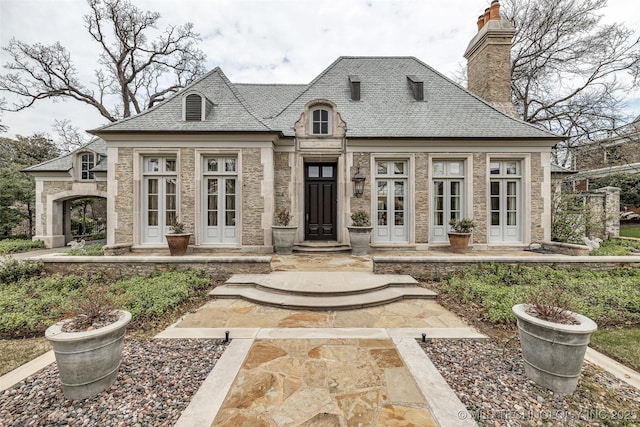 2119 E 30th Pl, Tulsa, OK 74114 - french provincial home featuring stone siding, a high end roof, a chimney, and french doors