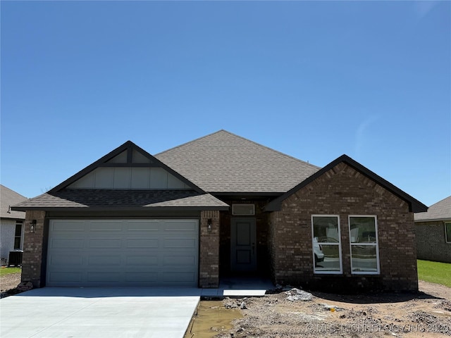 view of front of home with a garage, brick siding, and driveway