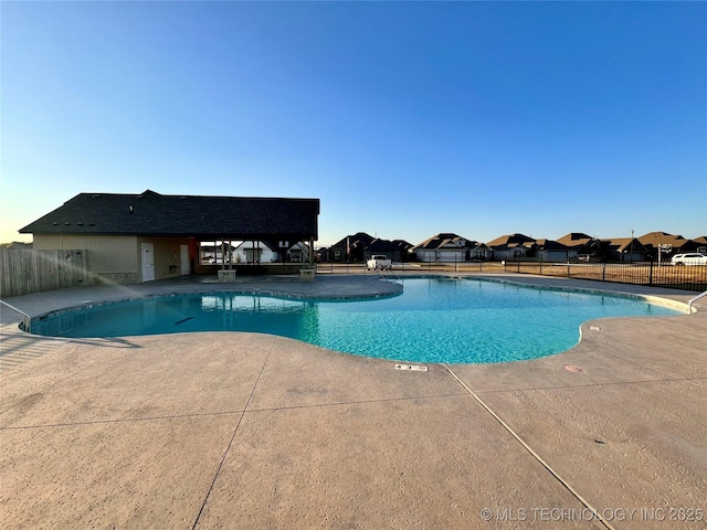 community pool featuring a patio and fence