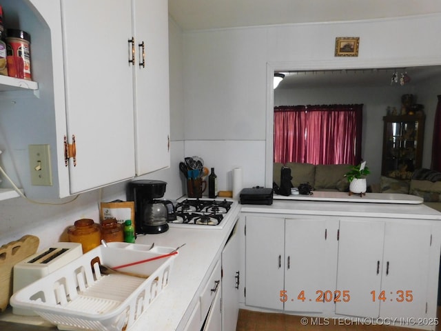 kitchen with light countertops, white cabinetry, and white gas cooktop