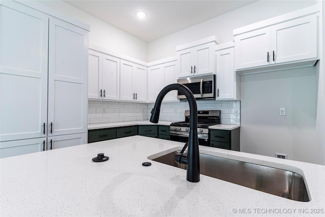 10914 S 272nd E Ave, Coweta, OK 74429 - kitchen with appliances with stainless steel finishes, light stone counters, backsplash, white cabinetry, and recessed lighting