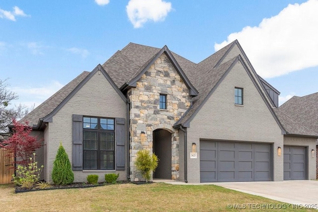 view of front of house featuring stone siding, roof with shingles, driveway, and a front yard