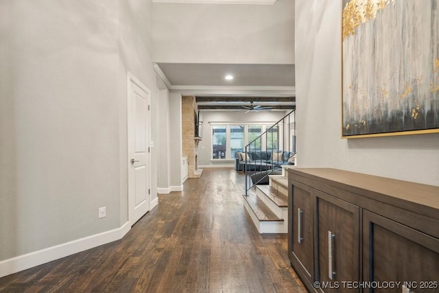 hall with baseboards, stairs, and dark wood finished floors
