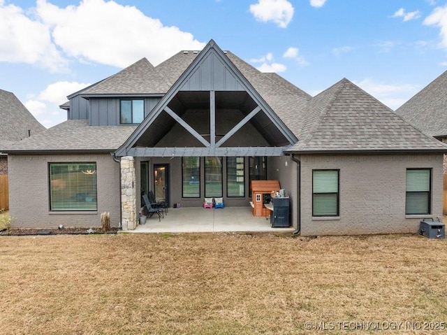 rear view of property featuring a yard, a patio, and roof with shingles