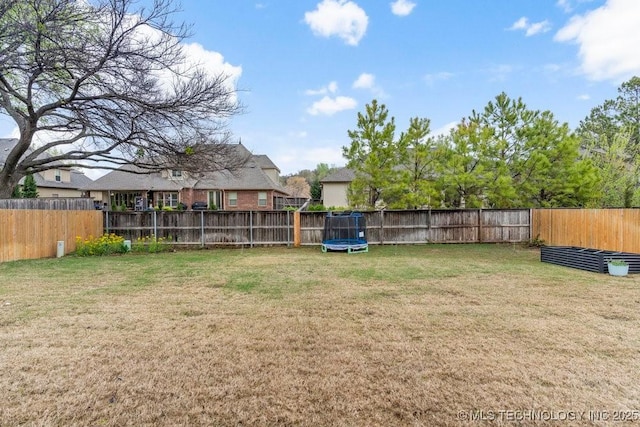 view of yard with a fenced backyard and a trampoline