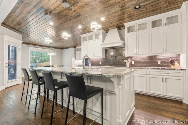 kitchen with white cabinets, wood ceiling, and custom range hood