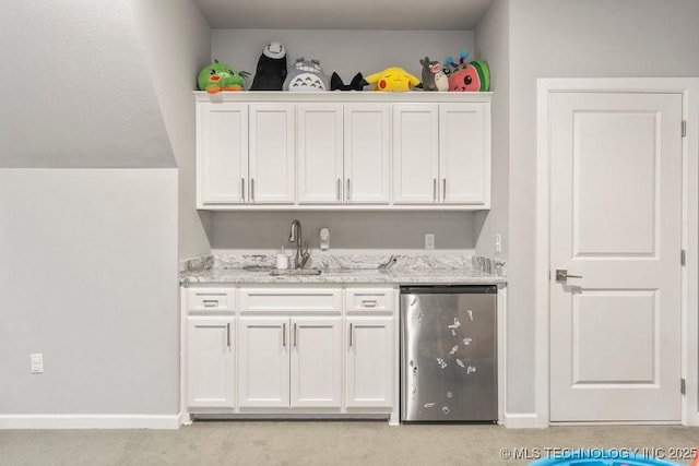 bar featuring baseboards, refrigerator, a sink, wet bar, and light colored carpet