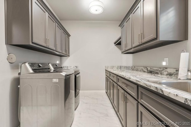 laundry room with washer and clothes dryer, a sink, cabinet space, marble finish floor, and baseboards