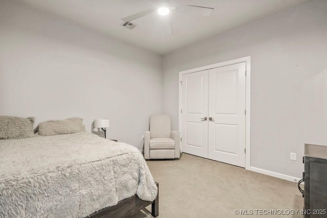 bedroom featuring a ceiling fan, a closet, visible vents, baseboards, and light carpet