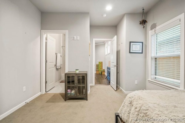 bedroom featuring light colored carpet and baseboards