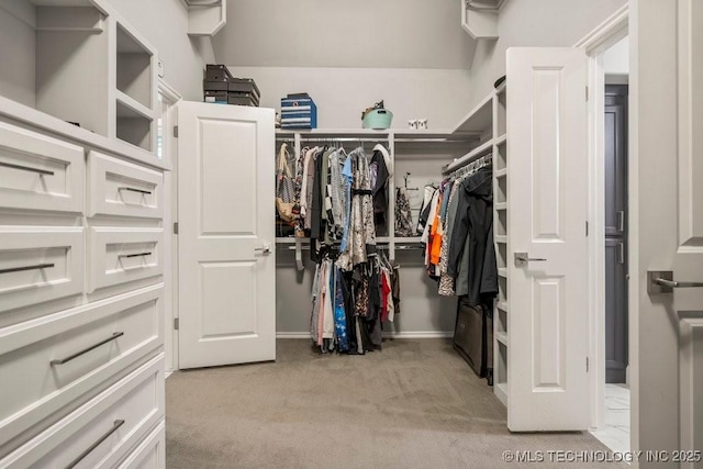 walk in closet featuring light colored carpet