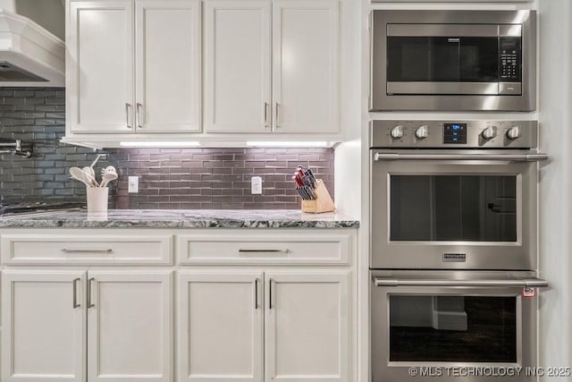 kitchen with stainless steel appliances, white cabinetry, and decorative backsplash