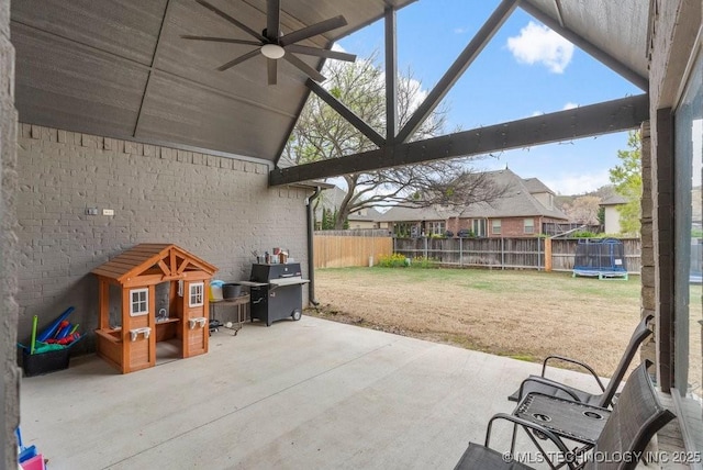 view of patio / terrace featuring a fenced backyard, ceiling fan, a trampoline, and a grill