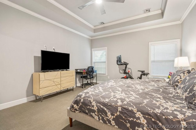 carpeted bedroom featuring baseboards, a raised ceiling, ornamental molding, and visible vents