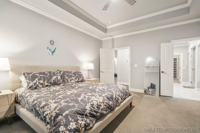 carpeted bedroom with baseboards, a raised ceiling, crown molding, and a ceiling fan