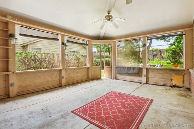 unfurnished sunroom featuring ceiling fan and plenty of natural light
