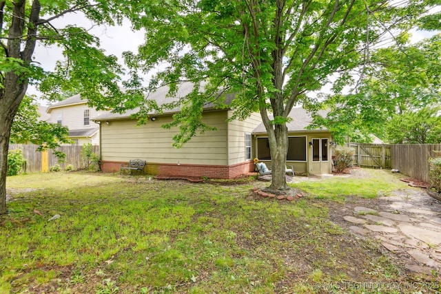rear view of property featuring a sunroom and a shingled roof