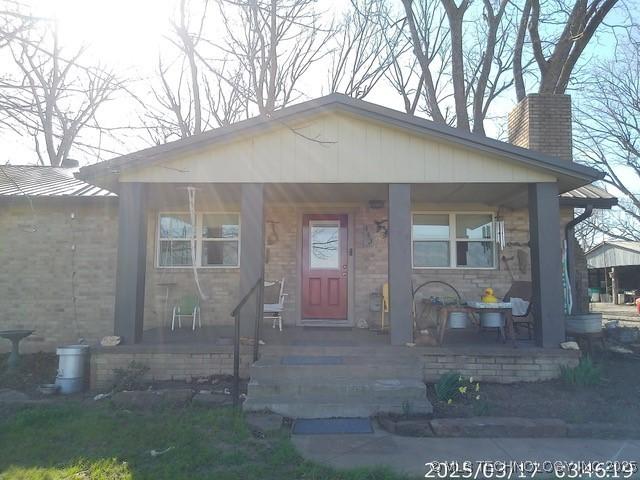 bungalow-style house with a porch and a chimney