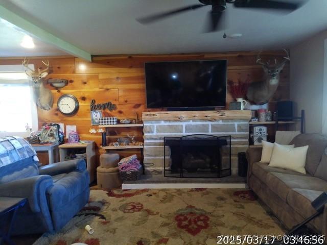 living room featuring a fireplace and a ceiling fan