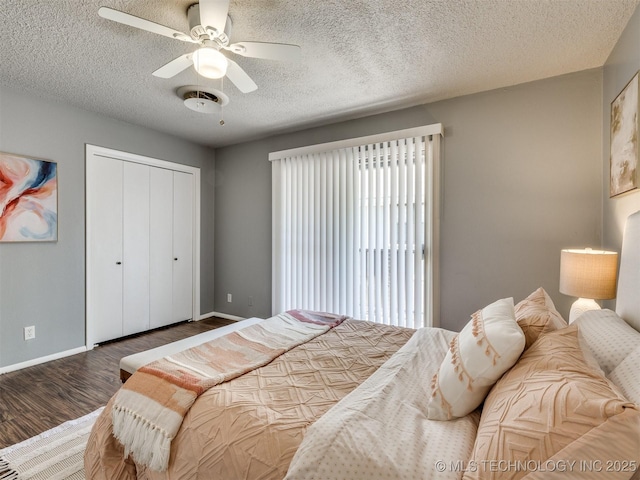 bedroom featuring a closet, a textured ceiling, baseboards, ceiling fan, and wood finished floors