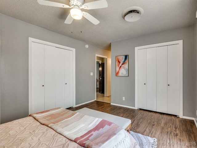 bedroom featuring a textured ceiling, baseboards, a ceiling fan, and wood finished floors