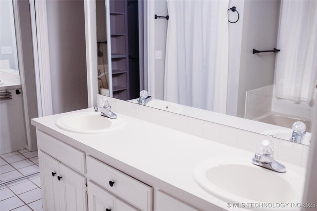 3926 W 15th Ave, Stillwater, OK 74074 - bathroom featuring double vanity, tile patterned floors, curtained shower, and a tub to relax in