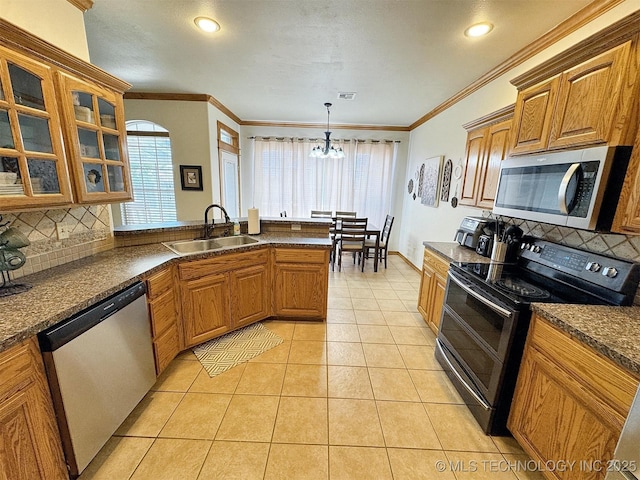 kitchen featuring a sink, stainless steel appliances, decorative backsplash, and dark countertops