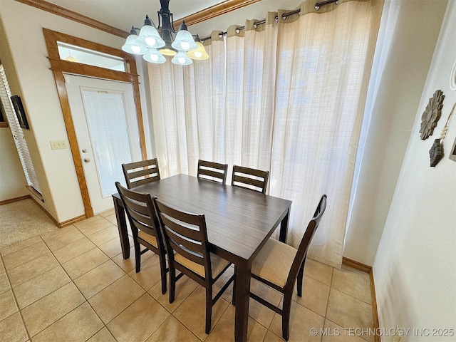 dining space with crown molding, light tile patterned floors, a chandelier, and baseboards