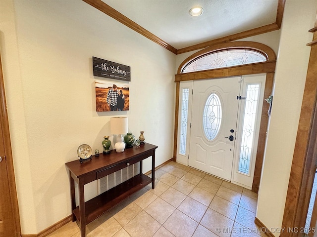entryway featuring baseboards, crown molding, and light tile patterned flooring
