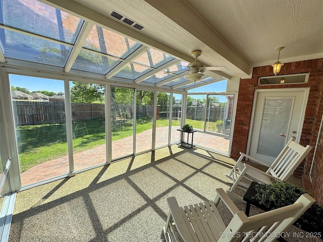 sunroom / solarium with ceiling fan, plenty of natural light, and visible vents