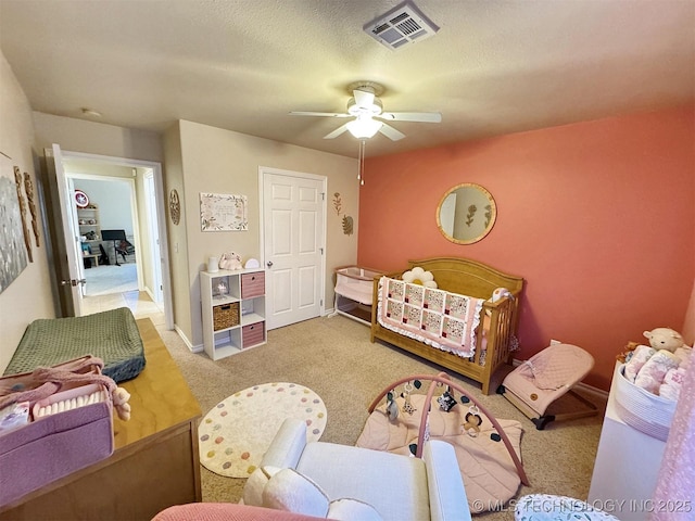 carpeted bedroom with baseboards, a ceiling fan, and visible vents