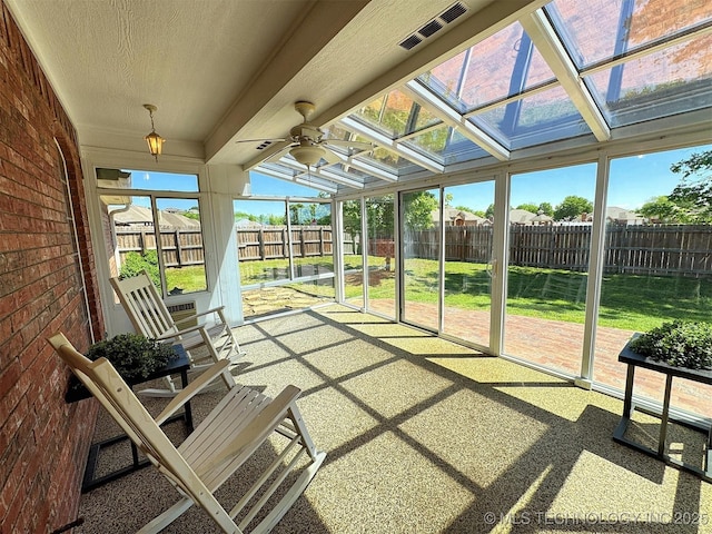 sunroom with a healthy amount of sunlight, ceiling fan, and visible vents
