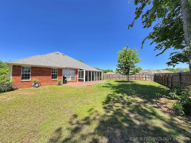 view of yard featuring a sunroom and a fenced backyard