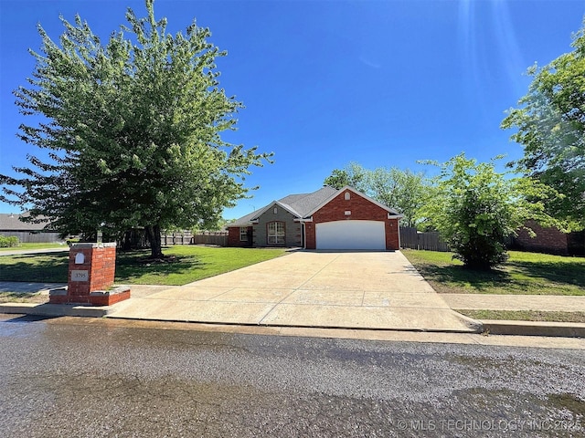 view of front facade with driveway, brick siding, fence, a garage, and a front yard
